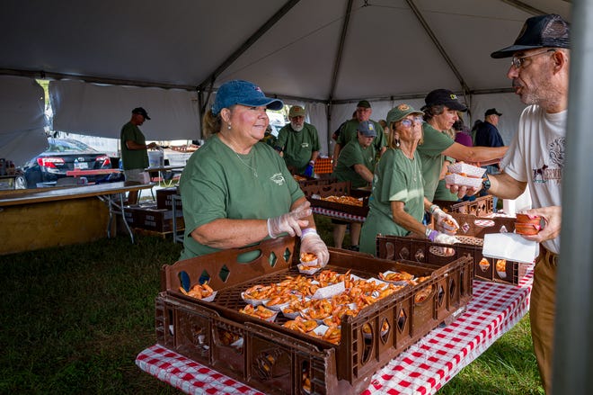 Los voluntarios sirven camarones al vapor.